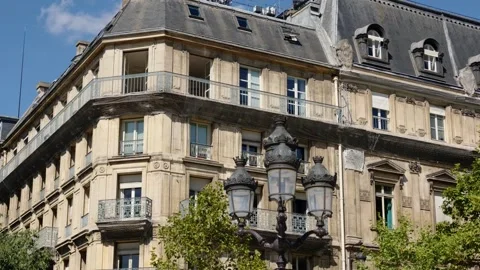 Historic Haussmann apartment building in Paris with ornate lamp post Vídeos de archivo 344831733