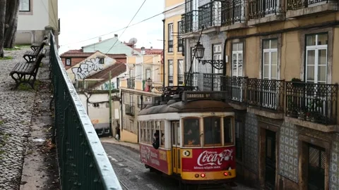 Historic Lisbon tram moving through Alfama street Vidéo 328838209