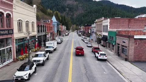 Historic main street of Wallace lined with brick storefronts, parked cars and Stock Footage 337529632