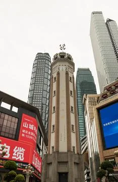 A historic octagonal clock tower stands in the center of a modern city cent.. Stock Photos