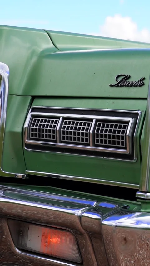 Historic old 70's car opening and turning on pop-up headlights Stock Footage 230079256