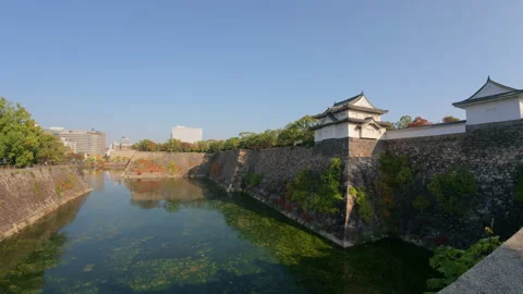 The historic Osaka Castle surrounded by the ancient outer moat in Japan Stock Footage 336101346
