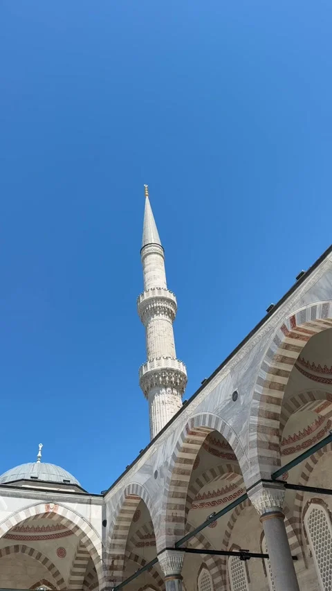 Historic Ottoman mosque courtyard with an elegant minaret, marble arches and Stock Footage 340897839