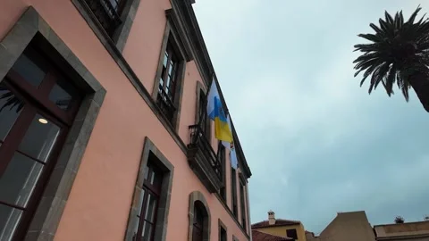 Historic peach building with flags in La Orotava, Tenerife, Canary Islands Stock Footage 346472665