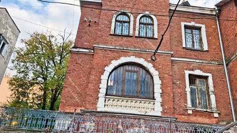 Historic Red Brick Building with Arched Windows and Ornate Facade Vídeos de archivo 347117553