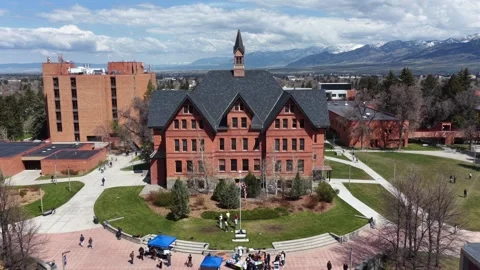 Historic red brick building with gabled roof and clock tower anchors university Stock Footage 337747585