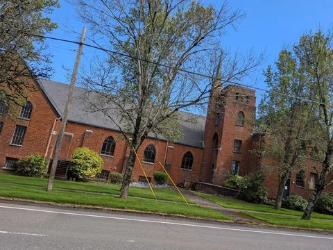 Historic red brick building surrounded by manicured lawn 库存照片