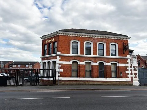 Historic red brick Hydes pub building on a city street in Manchester, UK wi.. Stock Photos