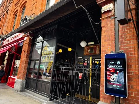 Historic red brick pub front with open late sign and digital poster on a bu.. Stock Photos