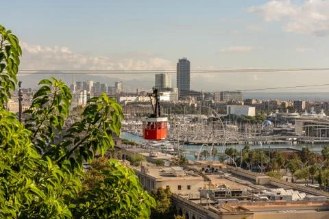 Historic red cable car cabin, steel towers, harbor and Barcelona city, spain Stock Photos