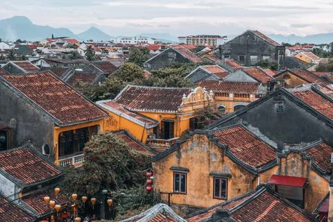 Historic rooftops of Hoi An with mountains in background Foto stock