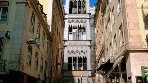 Historic Santa Justa elevator between Lisbon buildings under blue sky Stock Footage 342702446
