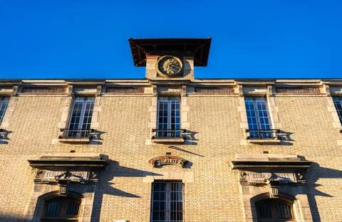Historic school building facade with clock in Saint-Ouen near Paris Stock Photos