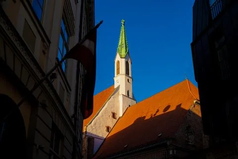 Historic St. Johns Church tower framed by Old Town Riga buildings 스톡 사진