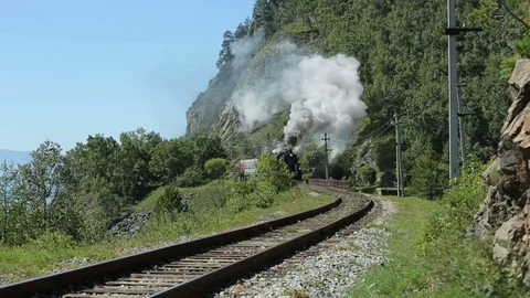 Historic steam train passes through the mountains. Steam locomotive moving Stock Footage 75762971