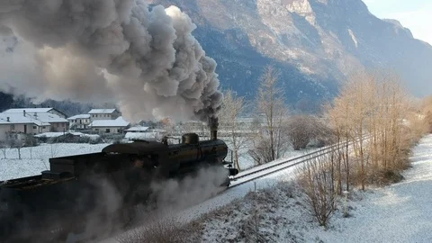 Historic steam train rolling through the snowy valley in a winter day Stock Footage 121429739