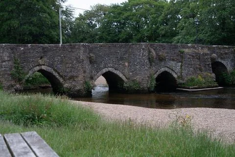 Historic stone arch bridge spanning river in quiet English countryside settin Stock-Fotos