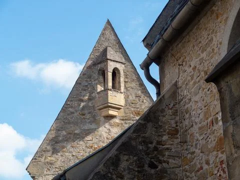 Historic stone building features a triangular tower against a bright blue s.. Stock Photos