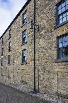 Historic stone building with rustic windows and a vintage street lamp. Rivi.. Stock Photos