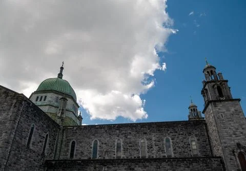 Historic stone cathedral under dramatic cloudy sky 库存照片