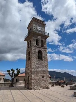 Historic Stone Clock Tower Under Cloudy Blue Sky in village of Arachova Foto stock