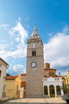 Historic stone clock tower under blue sky in quaint village. Omialj, Krk is.. Foto stock