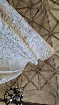 Historic stone column under vaulted ceiling Фото