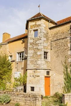 Historic stone tower with small windows and an orange entrance door, Yonne,.. Stock Photos
