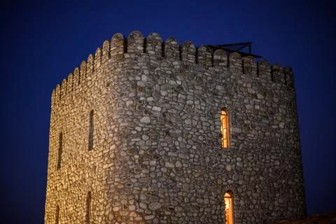 A historic stone tower at twilight, featuring a robust cylindrical shape wi.. Stock Photos