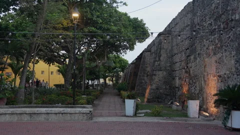 Historic Stone Wall and Lush Garden Pathway in Cartagena Old Town at Dusk Stock Footage 344409017