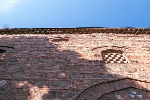 Historic stone wall with unique architectural details and a bright blue sky.. Stock Photos