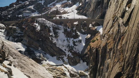 Historic Teufelsbrücke Devil's Bridge stone arch spanning deep snowy alpine Stock Footage 333987966