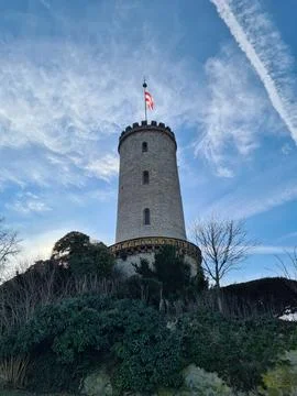 A Historic Tower Featuring a Flag is Set Against a Beautiful and Serene Sky Stock Photos