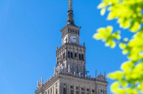 Historic tower showing clock face detail against blue sky. The Palace of Cult Stock Photos