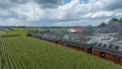 Historic Train Beside Cornfields Under Cloudy Skies Foto stock