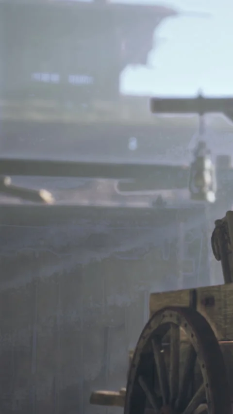 Historic wagon wheel in a dusty barn with soft light creating shadows Stock Footage 337999428