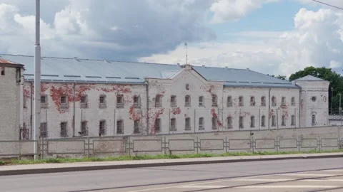 Historic white brick prison facility facade view along street in Daugavpils Stock Footage 343733880