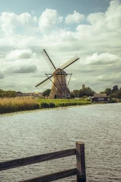 Historic windmill viewed through tall meadow grass in Kinderdijk Stock Photos