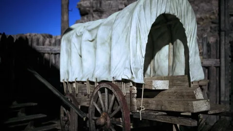 Historical covered wagon resting on rough terrain and rocky ridge Stock Footage 342432370