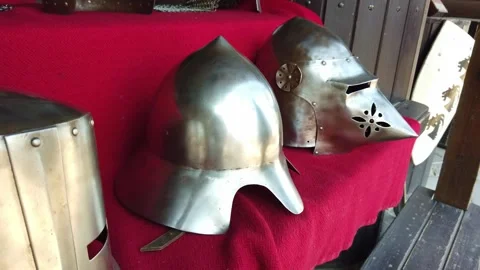 Historical knight helmets and armor displayed on red cloth indoors Video stock 342131702