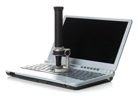 Historical old microscope on laptop computer keyboard Stock Photos