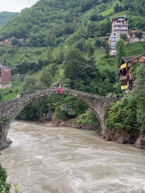 Historical Stone Arch Bridge Spanning a Rushing Mountain River Stock Footage 339880514