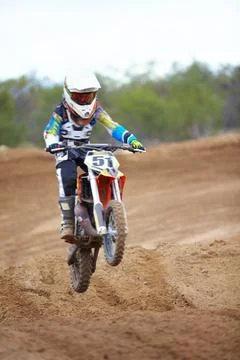 Hitting each ramp with purpose. A motocross rider taking a small jump. Stock Photos