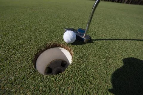 Hitting golf ball to hole Stock-Fotos