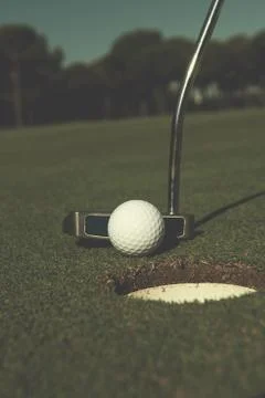 Hitting golf ball to hole Stock Photos