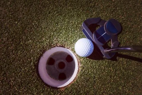 Hitting golf ball to hole Stock-Fotos