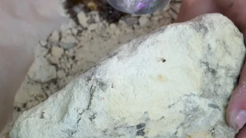 Hitting marlstone Rock with Hammer Stock Footage 276423807