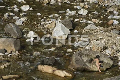 Hmong tribe little girl entering naked in the creek ~ Premium Photo