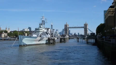 HMS Belfast and Tower Bridge crossing the River Thames, London Stock Footage 289851923