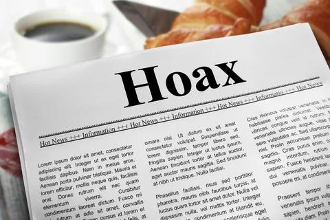 Hoax in newspaper layout on a breakfast table with a blurry cup of coffee a.. Stock Photos